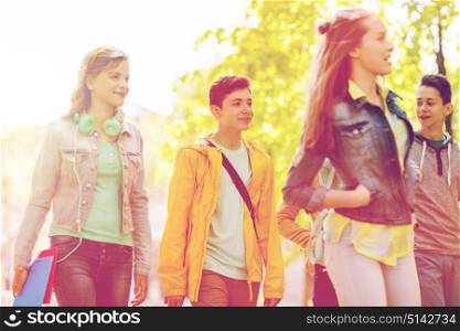education, high school, communication and people concept - group of happy teenage students walking outdoors. group of happy teenage students walking outdoors