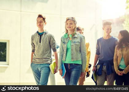 education, high school, communication and people concept - group of happy teenage students walking outdoors. group of happy teenage students walking outdoors. group of happy teenage students walking outdoors