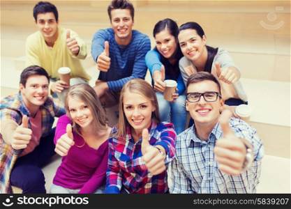 education, high school, friendship, drinks and people concept - group of smiling students with paper coffee cups showing thumbs up gesture
