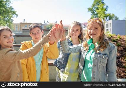 education, high school, friendship, gesture and people concept - group of happy teenage students or friends making high five outdoors