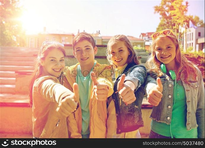 education, high school, friendship, gesture and people concept - group of happy teenage students or friends showing thumbs up outdoors. happy students or friends showing thumbs up