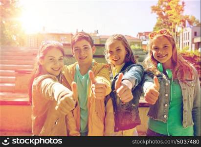 education, high school, friendship, gesture and people concept - group of happy teenage students or friends showing thumbs up outdoors. happy students or friends showing thumbs up
