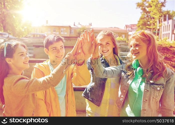 education, high school, friendship, gesture and people concept - group of happy teenage students or friends making high five outdoors. happy students or friends making high five