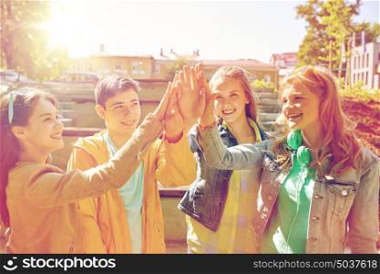 education, high school, friendship, gesture and people concept - group of happy teenage students or friends making high five outdoors. happy students or friends making high five