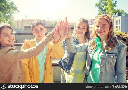 education, high school, friendship, gesture and people concept - group of happy teenage students or friends making high five outdoors. happy students or friends making high five. happy students or friends making high five