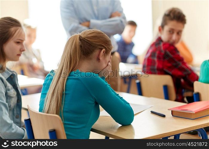 education, high school, learning and people concept - crying student girl with bad test result and teacher in classroom