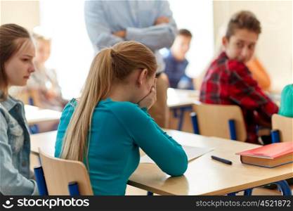 education, high school, learning and people concept - crying student girl with bad test result and teacher in classroom