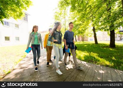 education, high school, learning and people concept - group of happy teenage students walking outdoors
