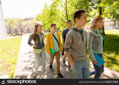 education, high school, learning and people concept - group of happy teenage students walking outdoors