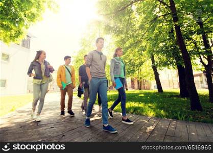 education, high school, learning and people concept - group of happy teenage students walking outdoors. group of happy teenage students walking outdoors. group of happy teenage students walking outdoors