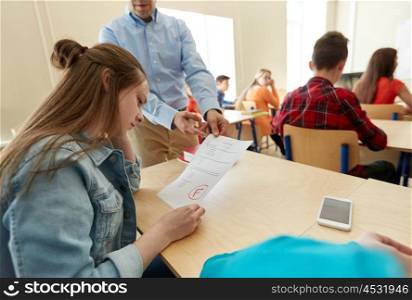 education, high school, learning and people concept - upset student girl with bad test result and teacher in classroom