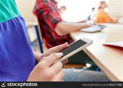 education, high school, learning, technology and people concept - close up of student girl with smartphone texting on lesson