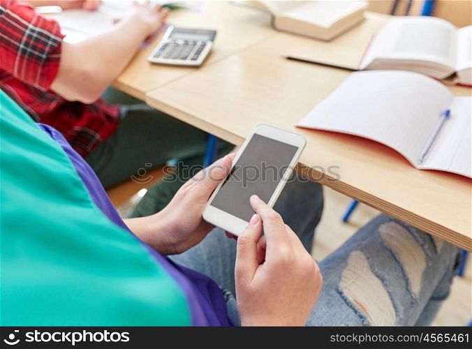 education, high school, learning, technology and people concept - student girl with smartphone texting on lesson