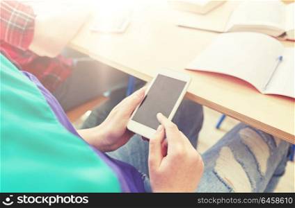 education, high school, learning, technology and people concept - student girl with smartphone texting on lesson. student girl with smartphone texting at school