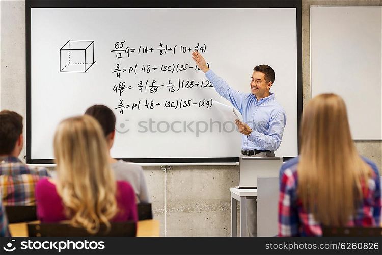 education, high school, mathematics and people concept - smiling teacher with notepad standing in front of students and showing mathematical equalities on white board in classroom