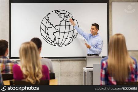 education, high school, teaching, geography and people concept - group of students and happy teacher with notepad showing earth globe drawing on white board in classroom