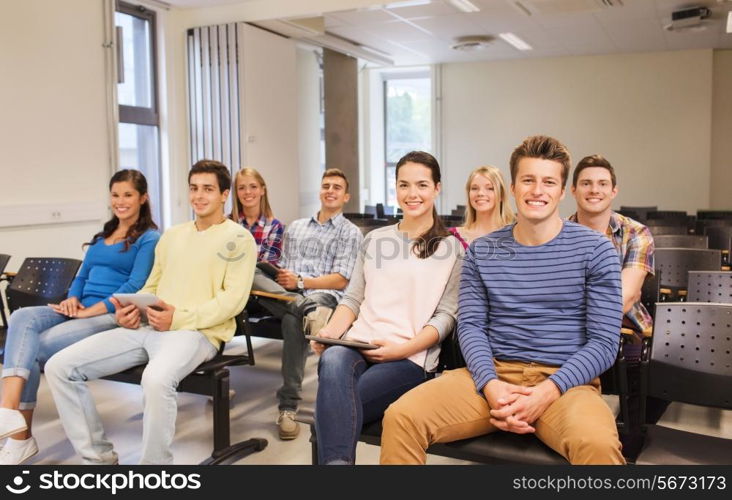 education, high school, teamwork and people concept - group of smiling students with tablet pc computers sitting in lecture hall