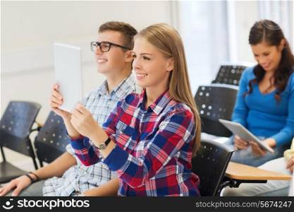 education, high school, teamwork and people concept - group of smiling students with tablet pc computers making photo or video in lecture hall