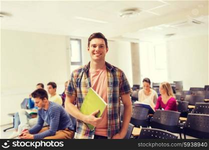 education, high school, teamwork and people concept - group of smiling students with notepads sitting in lecture hall