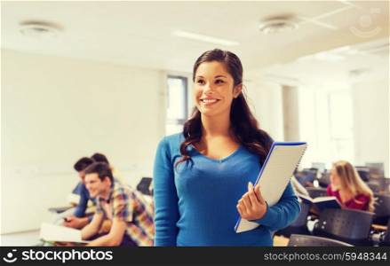 education, high school, teamwork and people concept - group of smiling students with notepads sitting in lecture hall