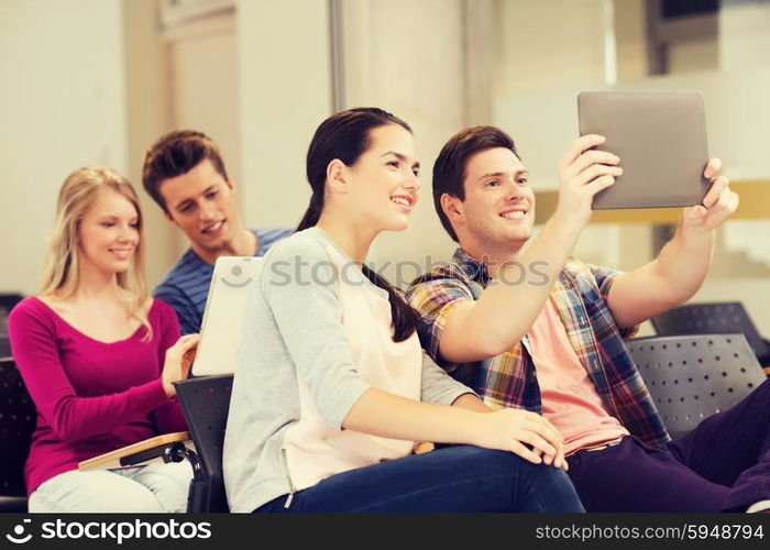 education, high school, teamwork and people concept - group of smiling students with tablet pc computers making photo or video in lecture hall