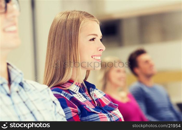 education, high school, teamwork and people concept - group of smiling students sitting in lecture hall