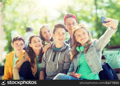 education, high school, technology and people concept - group of happy teenage students or friends taking selfie by smartphone. happy teenage students taking selfie by smartphone. happy teenage students taking selfie by smartphone