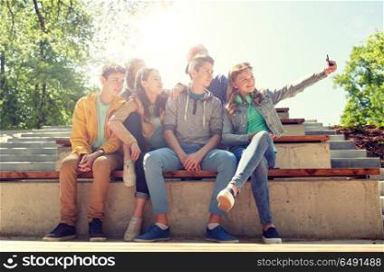 education, high school, technology and people concept - group of happy teenage students or friends taking selfie by smartphone. happy teenage students taking selfie by smartphone. happy teenage students taking selfie by smartphone