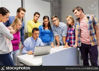 education, high school, technology and people concept - group of students and teacher with laptop computer in classroom. students and teacher with laptop at school