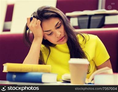 education, high school, university, learning and people concept - bored student girl with books and coffee on lecture. student girl with books and coffee on lecture