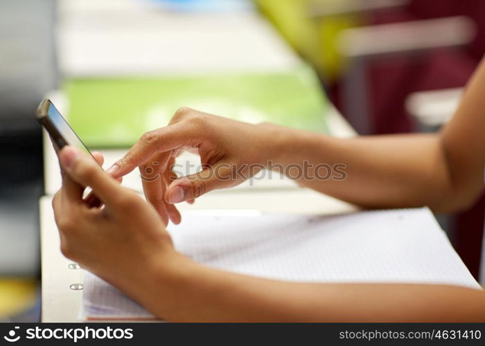 education, high school, university, learning and people concept - close up of african student girl hands with smartphone on lecture