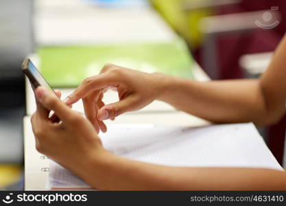 education, high school, university, learning and people concept - close up of african student girl hands with smartphone on lecture