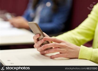 education, high school, university, learning and people concept - close up of student girls with smartphones on lecture