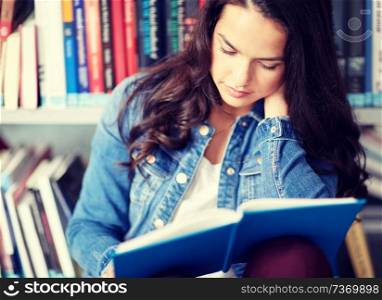 education, high school, university, learning and people concept - close up of student girl reading book sitting on floor at library. high school student girl reading book at library