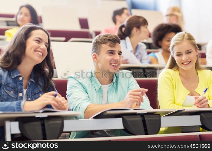 education, high school, university, learning and people concept - group of international students with notebooks in lecture hall