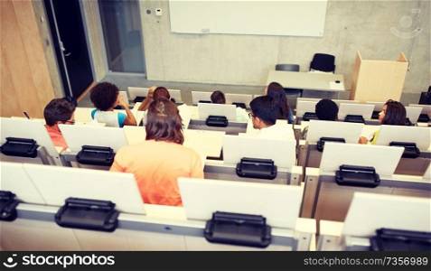 education, high school, university, learning and people concept - group of international students in lecture hall. international students at university lecture hall