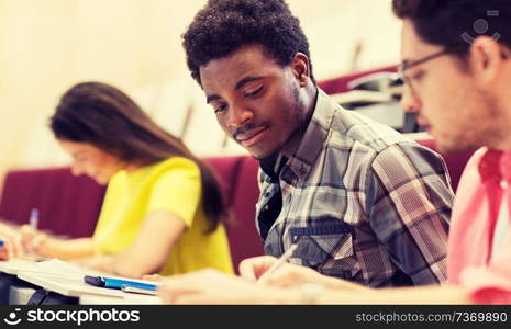 education, high school, university, learning and people concept - group of international students in lecture hall. group of international students in lecture hall