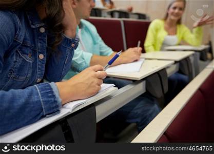 education, high school, university, learning and people concept - group of students with notebooks at lecture hall