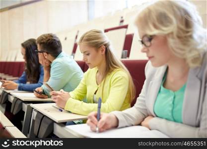 education, high school, university, learning and people concept - group of students with smartphones at lecture