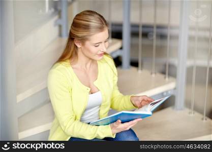 education, high school, university, learning and people concept - smiling student girl reading book sitting on stairs
