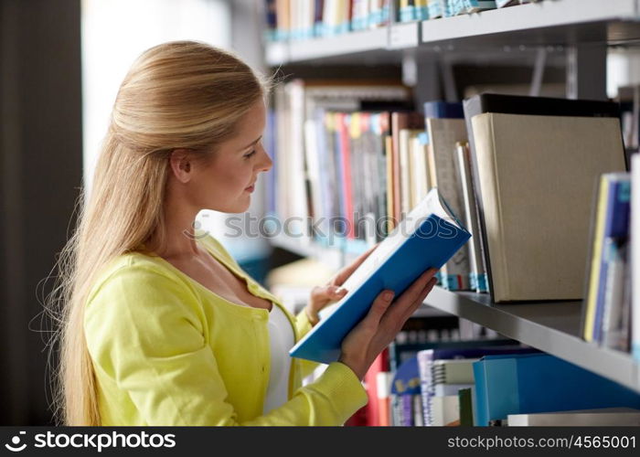 education, high school, university, learning and people concept - smiling student girl reading book at library