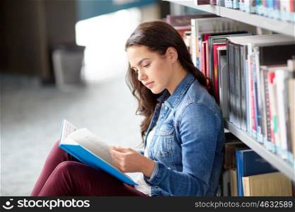 education, high school, university, learning and people concept - student girl reading book sitting on floor at library