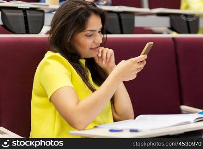 education, high school, university, learning and people concept - student girl with smartphone on lecture