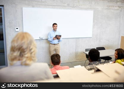 education, high school, university, teaching and people concept - group of international students and teacher with tablet pc computer standing at white board at lecture