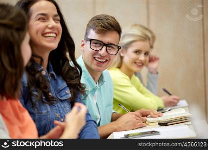 education, high school, university, vision and people concept - young man in eyeglasses with group of students at lecture. group of students at lecture