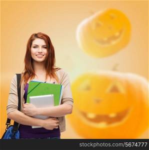education, holidays, school and people concept - smiling student girl with books and bag over halloween pumpkins background