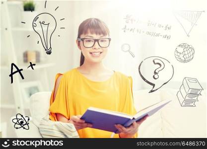 education, knowledge, vision, literature and people concept - smiling young asian woman or student girl in glasses reading book at home over school doodles. smiling young asian woman reading book at home. smiling young asian woman reading book at home