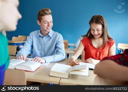 education, learning and people concept - group of students with books at school lesson