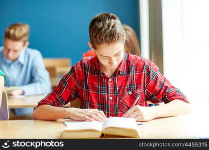 education, learning and people concept - group of students with books writing school test