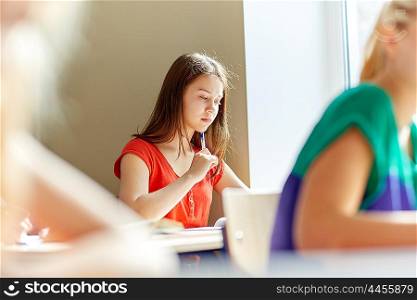 education, learning and people concept - group of students with books writing school test
